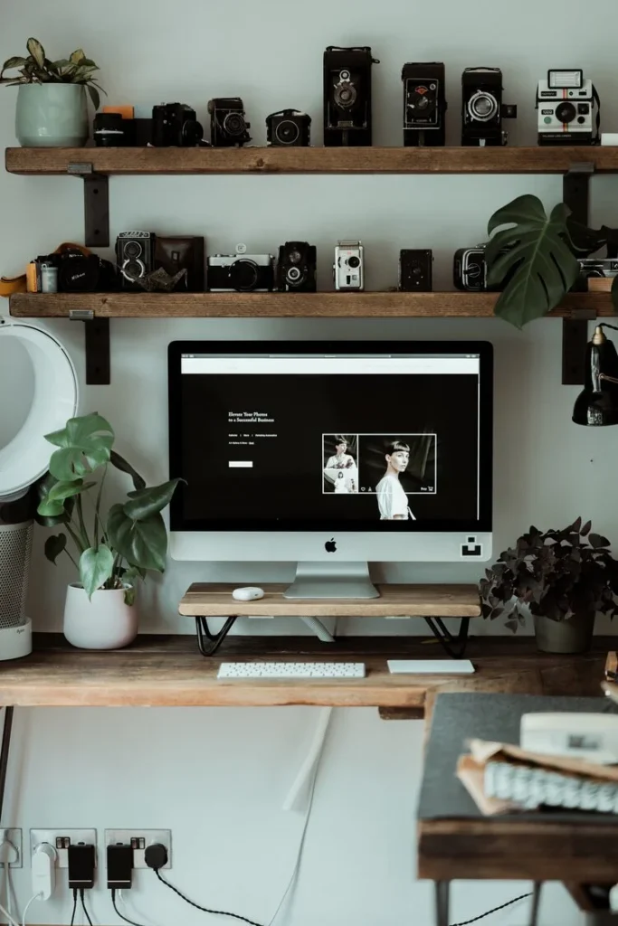 Modern workspace with a computer and vintage cameras display
